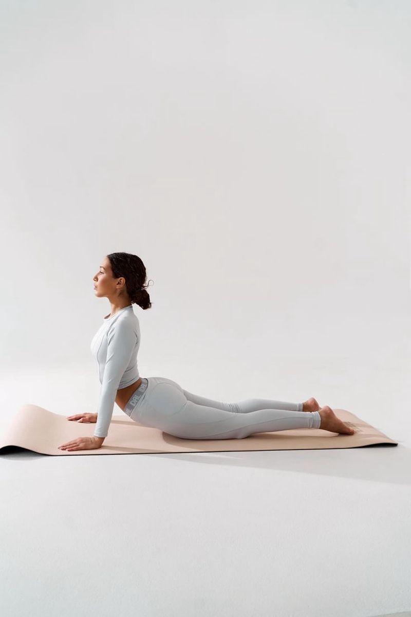 Practitioner lying in Savasana for Yoga Nidra, covered with a blanket for deep relaxation